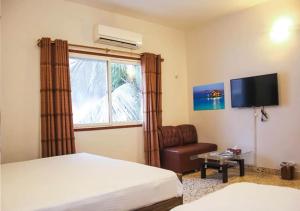 a bedroom with a bed and a chair and a window at Motel Royal Fantasy in Karachi