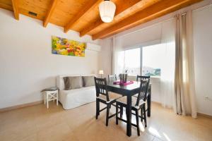 a dining room with a table and chairs and a couch at Sa Caseta La Casita in La Savina
