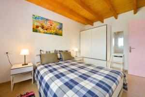 um quarto com uma cama com um cobertor xadrez azul e branco em Sa Caseta La Casita em La Savina