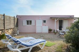 eine Terrasse mit 2 Liegestühlen und ein Haus in der Unterkunft Sa Caseta La Casita in La Savina