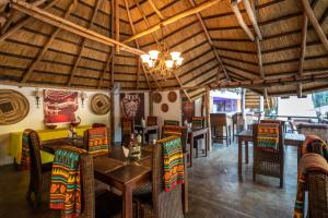 um restaurante com mesas e cadeiras e um lustre em Ngoma Zanga Lodge em Livingstone