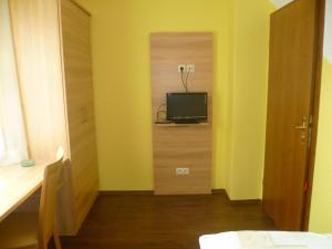 a room with a television and a room with a door at Hotel Thünenhof in Oyten