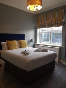 um quarto com uma cama grande com dois bichos de peluche em The Royal Oak em Woodford