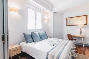 a bedroom with a bed with blue pillows and a desk at Gran Via Apartment by People Rentals in Bilbao
