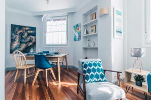 a dining room with blue walls and a table and chairs at Gran Via Apartment by People Rentals in Bilbao