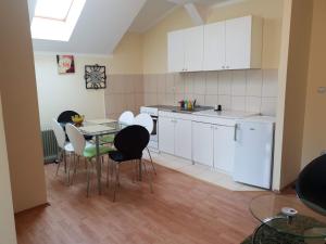 a kitchen with white cabinets and a table and chairs at Apartman Vid in Soko Banja