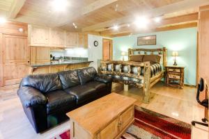 a living room with a leather couch and a bed at Sun Valley Atelier Studio - Chic Rustique in Sun Valley