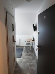 a hallway with a room with a table and a door at Noclegi u Andrzeja in Gdańsk
