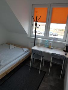 1 dormitorio con cama, mesa y ventana en Noclegi i Parking u Andrzeja en Gdansk