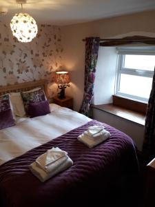 a bedroom with a bed with two towels on it at The Black Bull at Nateby in Kirkby Stephen