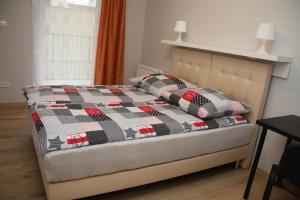uma cama com uma colcha e duas almofadas em Apartament Matejki em Łódź