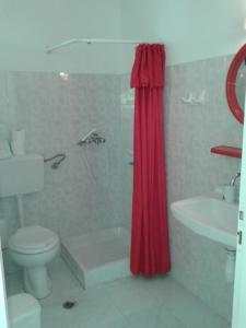 イリアにあるBalaska Houseのバスルーム(トイレ、赤いシャワーカーテン付)