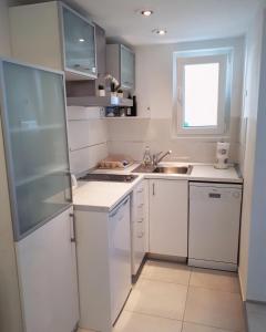 a white kitchen with a sink and a refrigerator at Accommodation Stella Mare in Bol