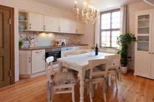 a kitchen with a table and chairs and a chandelier at Apartmenthaus im holländischen Viertel in Potsdam