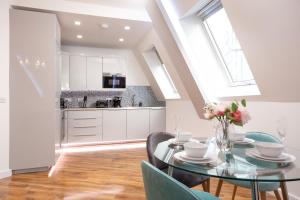 a kitchen and dining room with a glass table and chairs at Leeds Super Luxurious Apartments in Leeds