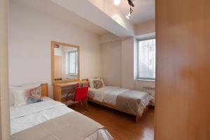 um quarto com 2 camas, uma secretária e um espelho. em RIS Central Apartments Yerevan em Yerevan
