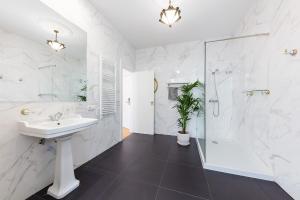 ein weißes Bad mit einem Waschbecken und einer Dusche in der Unterkunft Contador Mor Rooms and Apartments in Lissabon
