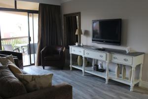 ダーバンにあるBeachfront Luxury @ Umhlangaのリビングルーム(テーブル上にテレビ付)