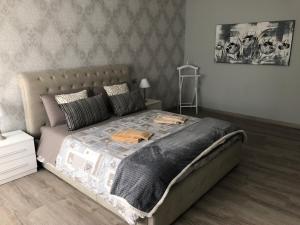 sypialnia z dużym łóżkiem z szarą kołdrą w obiekcie Masia Holiday Apartment Como Lake w Como