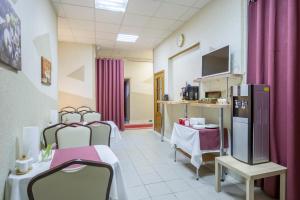 a hospital room with tables and chairs and a tv at Iskra Hotel in Saint Petersburg