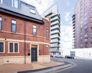 a red brick building with a blue door on a street at Leeds Super Luxurious Apartments in Leeds