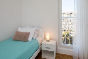 a small bedroom with a bed and a window at Sidro apartment in Split