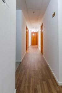 an empty corridor in an office building with wooden doors at AYZ Javier Cabrini - Auto check-in property in Madrid