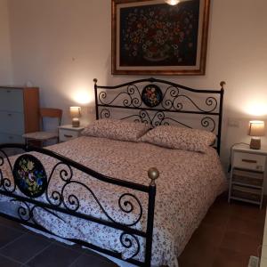 ein Schlafzimmer mit einem schwarzen Bett mit einem Bild an der Wand in der Unterkunft Il Ciliegio del Pellegrino in Gubbio