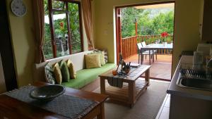 ein Wohnzimmer mit einem grünen Sofa und einem Tisch in der Unterkunft Lent@Grootbrak in Groot Brak Rivier