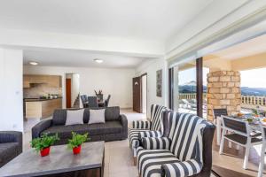 Una sala de estar con un sofá y sillas y una mesa. en Aqua View, en Kissonerga