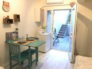 a small kitchen with a green table and a refrigerator at Two Houses Petralona in Athens