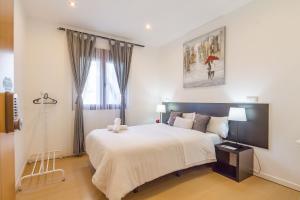 a bedroom with a large white bed and a window at AYZ Javier Cabrini - Auto check-in property in Madrid