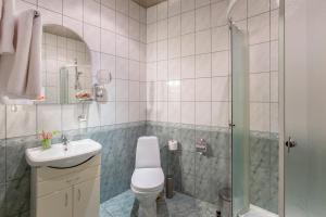 y baño con ducha, aseo y lavamanos. en Iskra Hotel, en San Petersburgo