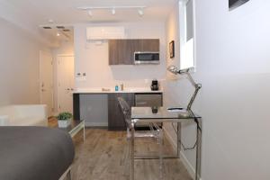 a small kitchen with a desk and a table in a room at A Stylish Stay w/ a Queen Bed, Heated Floors.. #1 in Brookline