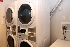 a white laundry room with two washing machines at A Stylish Stay w/ a Queen Bed, Heated Floors.. #1 in Brookline