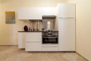 a white kitchen with a stove and a refrigerator at Narciso Centralissimo in Sanremo