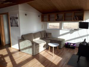 ein Wohnzimmer mit einem Sofa und einem Tisch in der Unterkunft Skjaldvararfoss sumarhús in Múli
