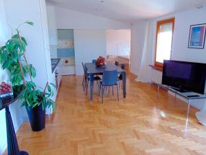 a living room with a dining table and a television at Casa Del Sole in Numana