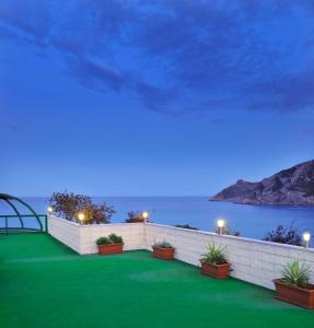 a resort with a green lawn and the ocean at night at KAKTUS Hotel Kaktus Albir in Albir
