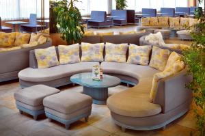 a waiting room with couches and a table and chairs at KAKTUS Hotel Kaktus Albir in Albir