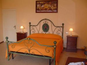 an orange bed in a bedroom with two lamps at Casa Flavia in Orvieto