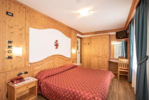 a bedroom with a red bed in a room at Hotel San Martino in San Martino di Castrozza +43 photos