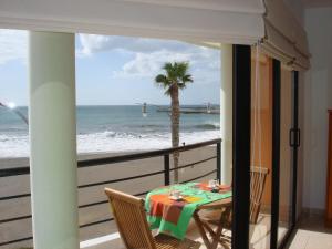 a table on a balcony with a view of the beach at Brisa Mar in Gran Tarajal
