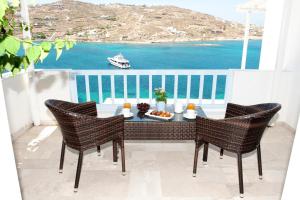 una mesa y sillas en un balcón con vistas al océano en Vana Holidays, en Ornos