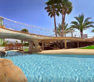a bridge over a swimming pool with a walkway at Hotel Kaktus Albir in Albir