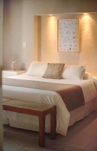 a bedroom with a large white bed and a table at Plenilunio Mar de las Pampas in Mar de las Pampas