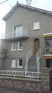 una casa con escaleras y un balcón en ella en Le rocher de bonnevie en Murat