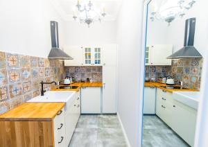a kitchen with white cabinets and wood counter tops at Old Town Boutique Rooms in Lublin