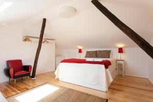 a bedroom with a bed and a red chair at Merces by Central Hill Apartments in Lisbon