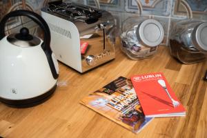 a kitchen counter with a toaster and a book on a table at Old Town Boutique Rooms in Lublin